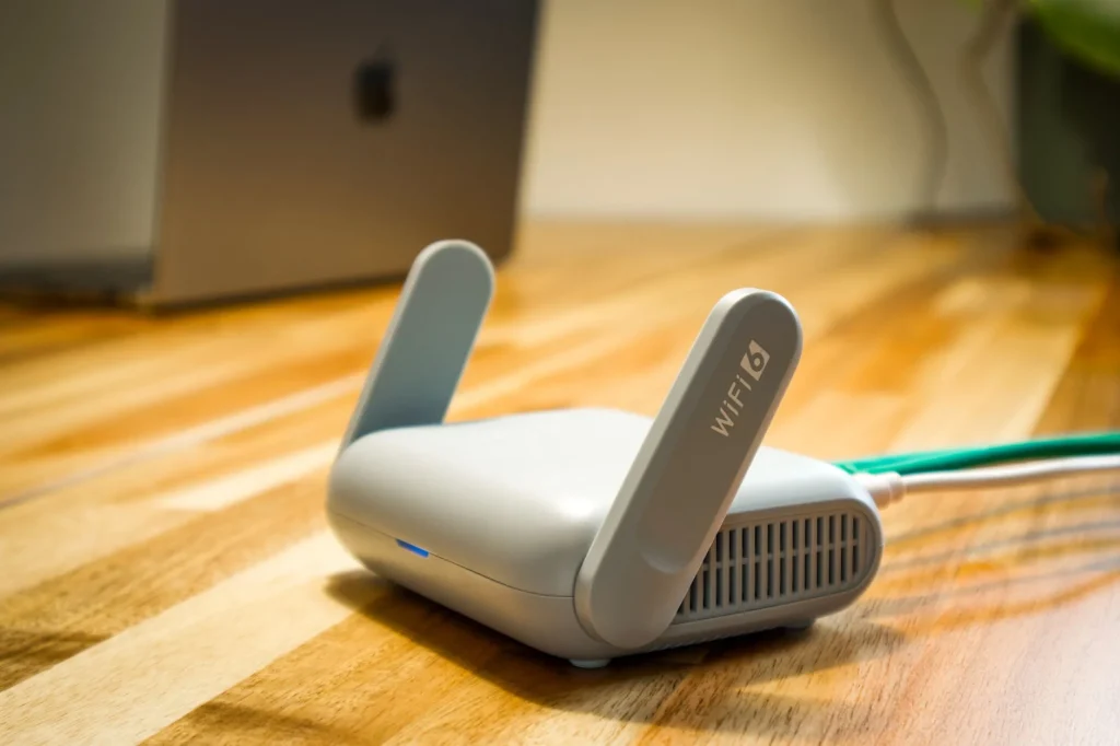 Routeur Wi-Fi domestique posé sur un bureau avec câbles réseau connectés