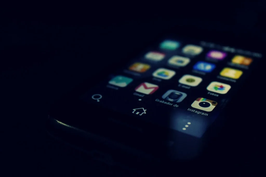 Écran de smartphone à thème sombre affichant diverses icônes d'applications mobiles