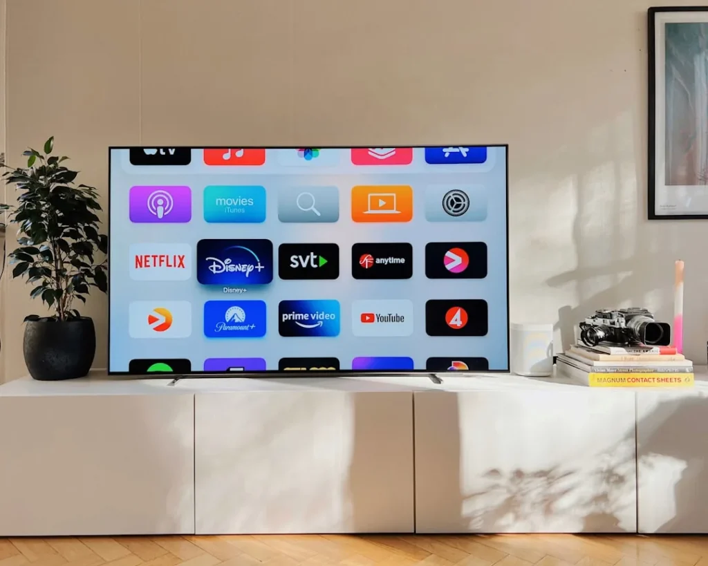 Un boitier smart TV connecté sur meuble blanc avec écran plat dans un salon moderne