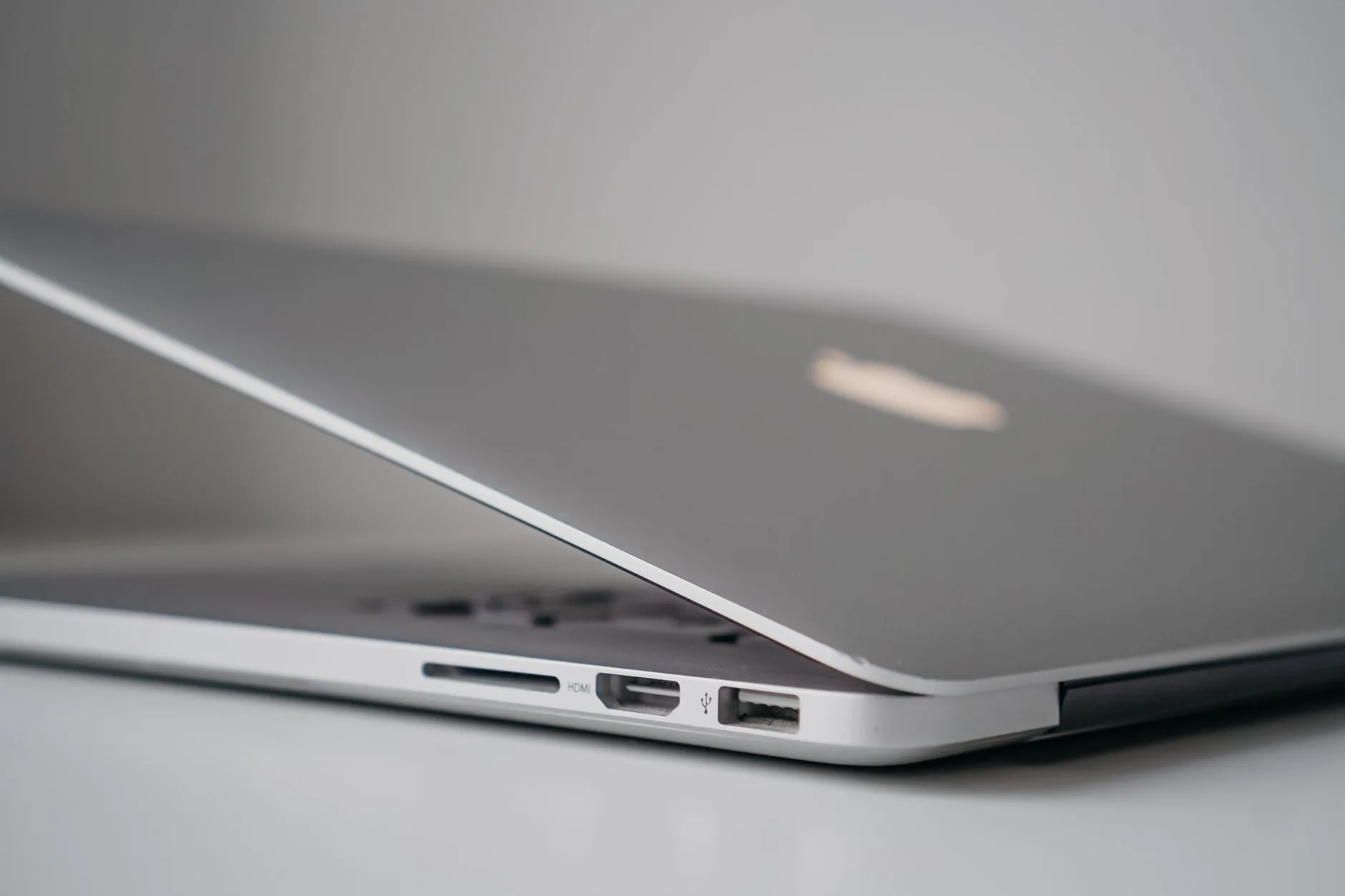 Un Mac portable argenté ouvert montrant son design épuré et ses ports de connexion