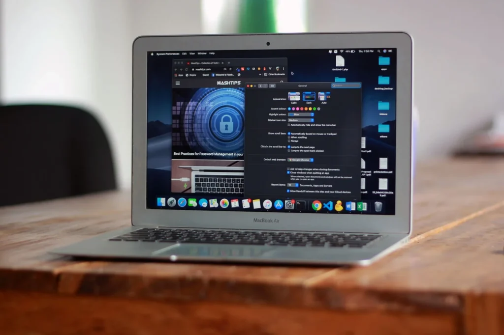 MacBook Air ouvert affichant applications et navigateur web sur table en bois