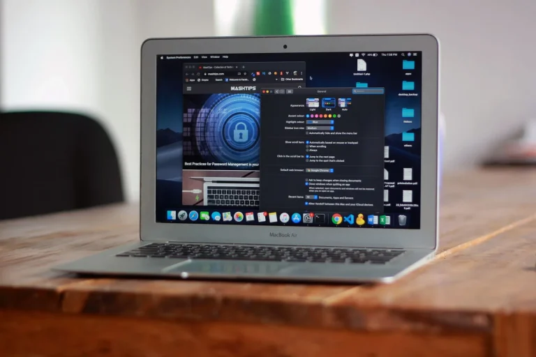 MacBook Air ouvert affichant applications et navigateur web sur table en bois