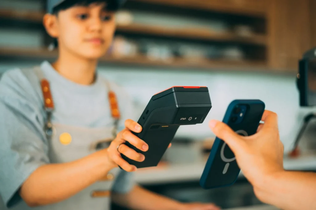 Un smartphone utilisant un tag NFC pour effectuer un paiement sans contact via un lecteur de carte