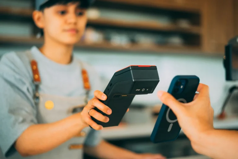 Un smartphone utilisant un tag NFC pour effectuer un paiement sans contact via un lecteur de carte