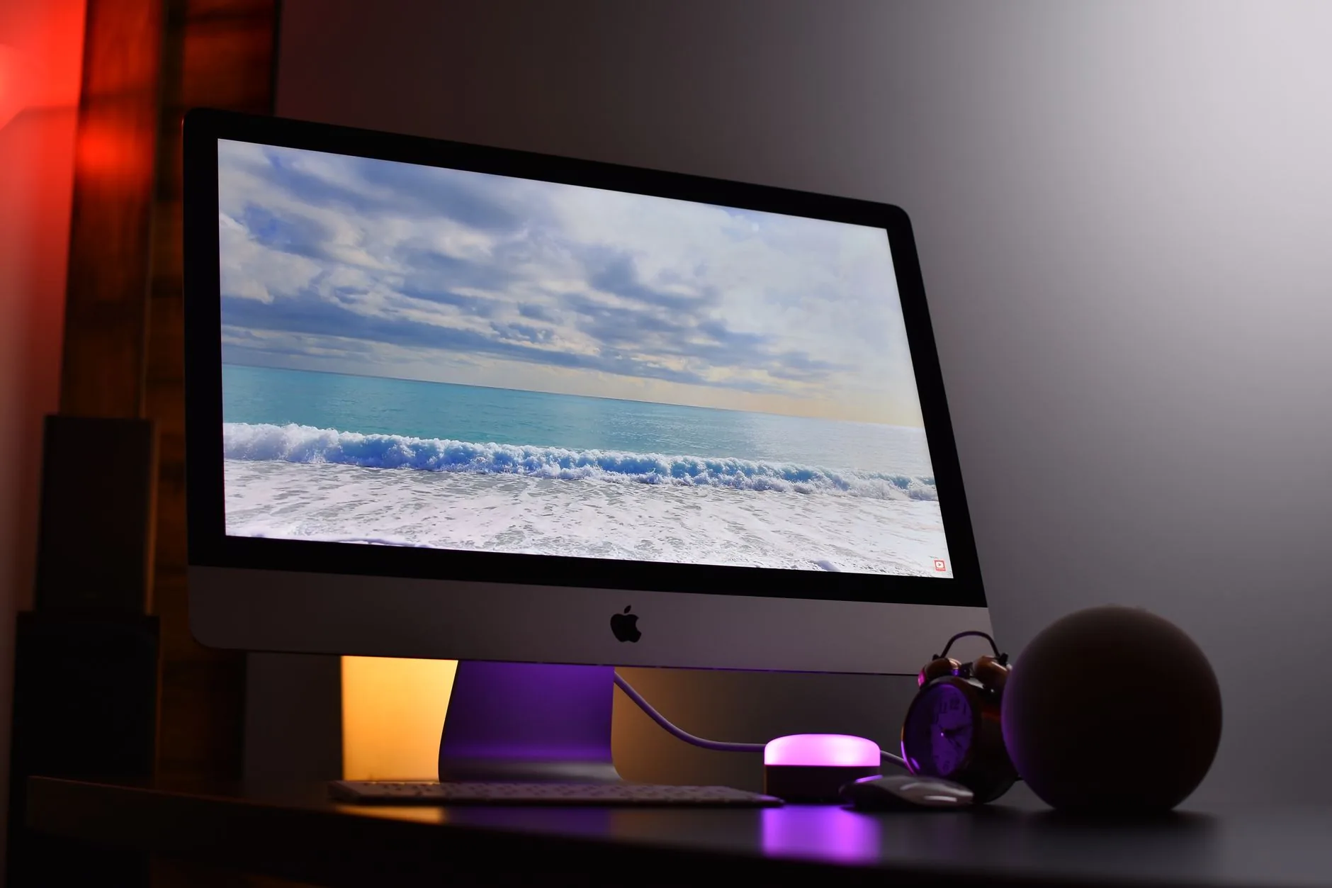 Un iMac affichant un fond informatique océanique dans un espace de travail moderne