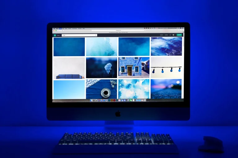 Espace de travail moderne avec fond informatique bleu et moniteur affichant galerie d'images