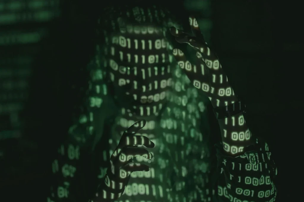 Personne avec code binaire projeté symbolisant les datas et la cybersécurité numérique