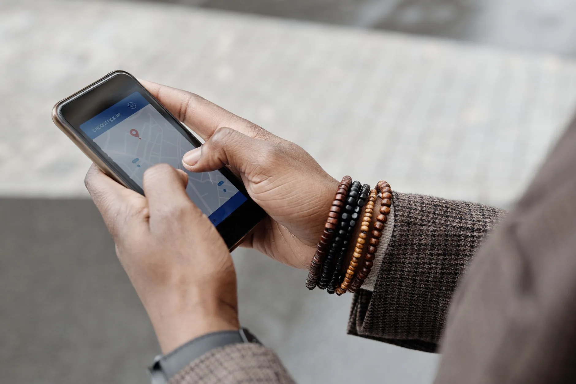Mains avec bracelets utilisant une application GPS sur smartphone à l'extérieur
