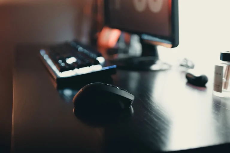 Gros plan sur une souris en informatique posée sur un bureau élégant avec clavier et moniteur