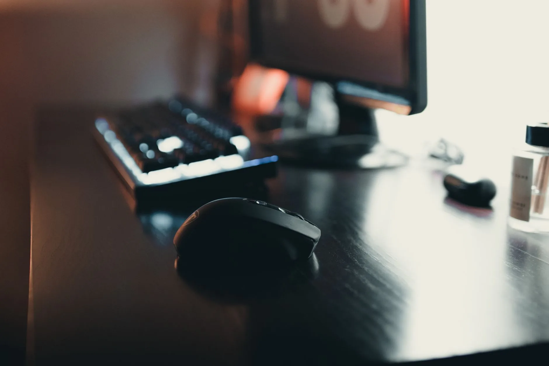 Gros plan sur une souris en informatique posée sur un bureau élégant avec clavier et moniteur