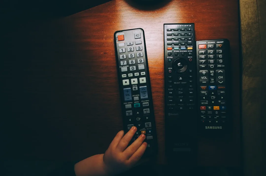 Trois télécommandes noires sur une table en bois montrant le fonctionnement infrarouge