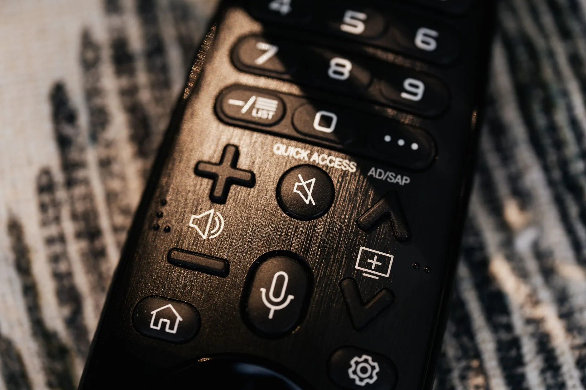 Gros plan d'une télécommande noire moderne montrant les boutons et fonctionnement détaillé